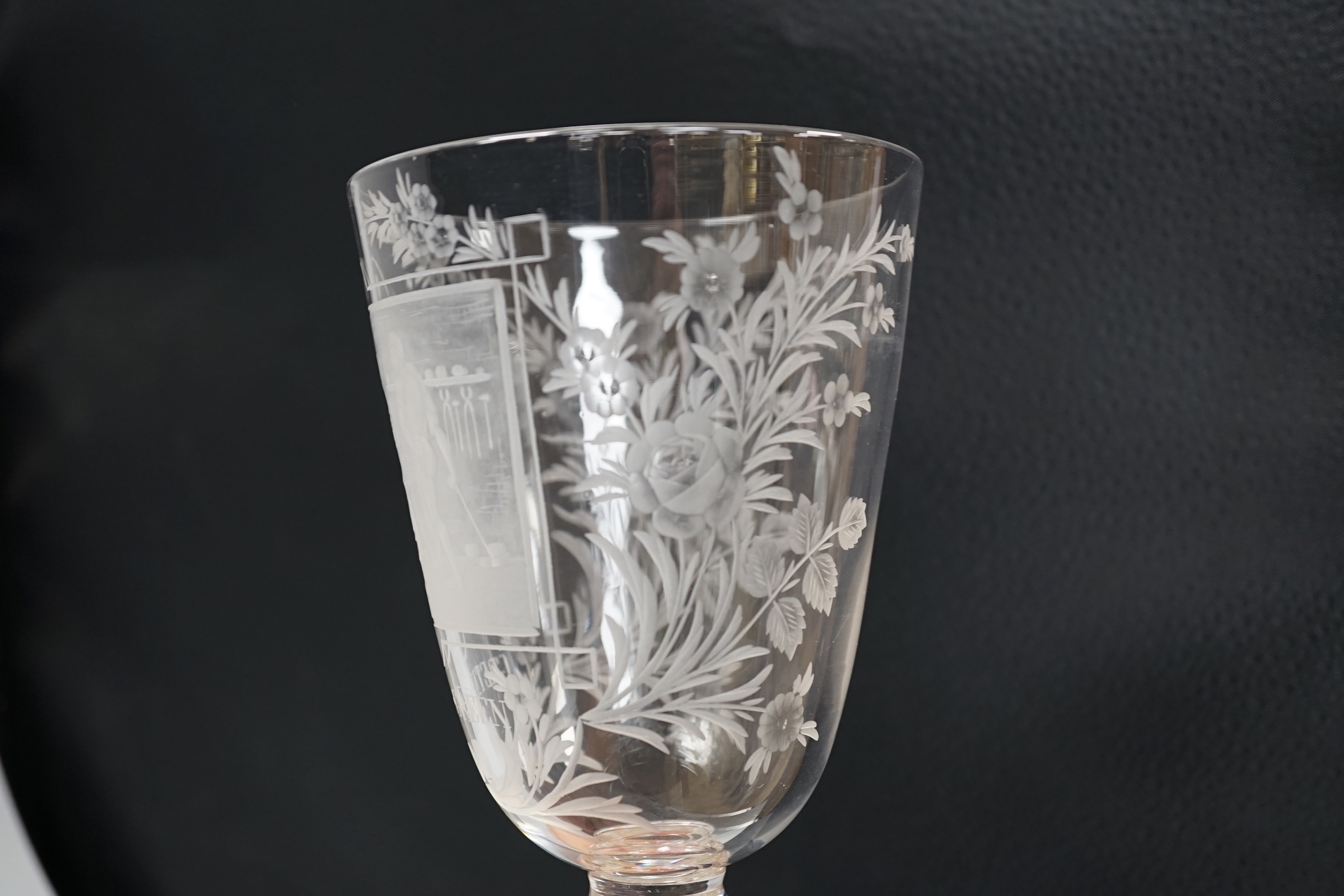 A lead crystal commemorative Gretna Green goblet, with fine engraving of a blacksmith and couple signing the register on an anvil, the panel surrounded by floral engraving, ‘GRETNA GREEN’ below, 23.9cm high